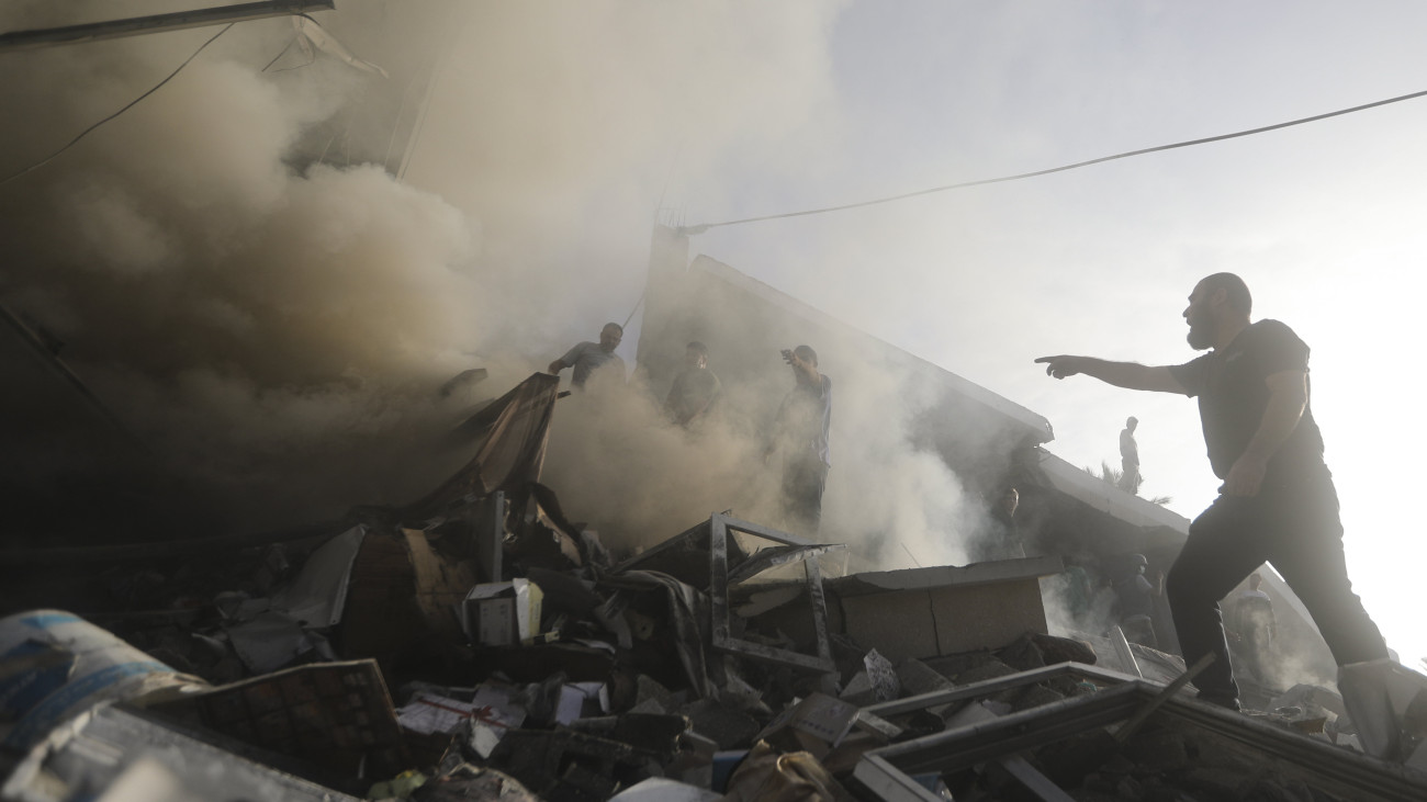 Palesztinok túlélők után kutatnak egy izraeli légicsapásban megsemmisült lakóépület romjai között a Gázai övezet déli részén fekvő Hán-Júniszban lévő menekülttáborban 2023. november 7-én. A Gázai övezetet irányító Hamász palesztin iszlamista szervezet fegyveresei október 7-én támadást indítottak Izrael ellen, több mint 1400 embert meggyilkoltak, további mintegy háromezret megsebesítettek, valamint 200-nál is több embert elraboltak és túszként tartanak fogva. Az izraeli válaszcsapások halálos áldozatainak száma átlépte a 9700-at, a sebesülteké pedig megközelíti a 25 ezret a palesztinok lakta területeken.