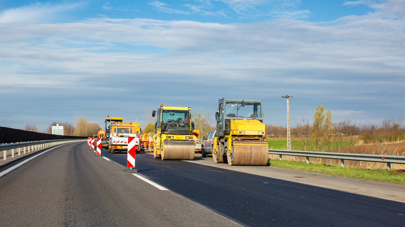 Road works on highway. Asphalt rollers and other equipment