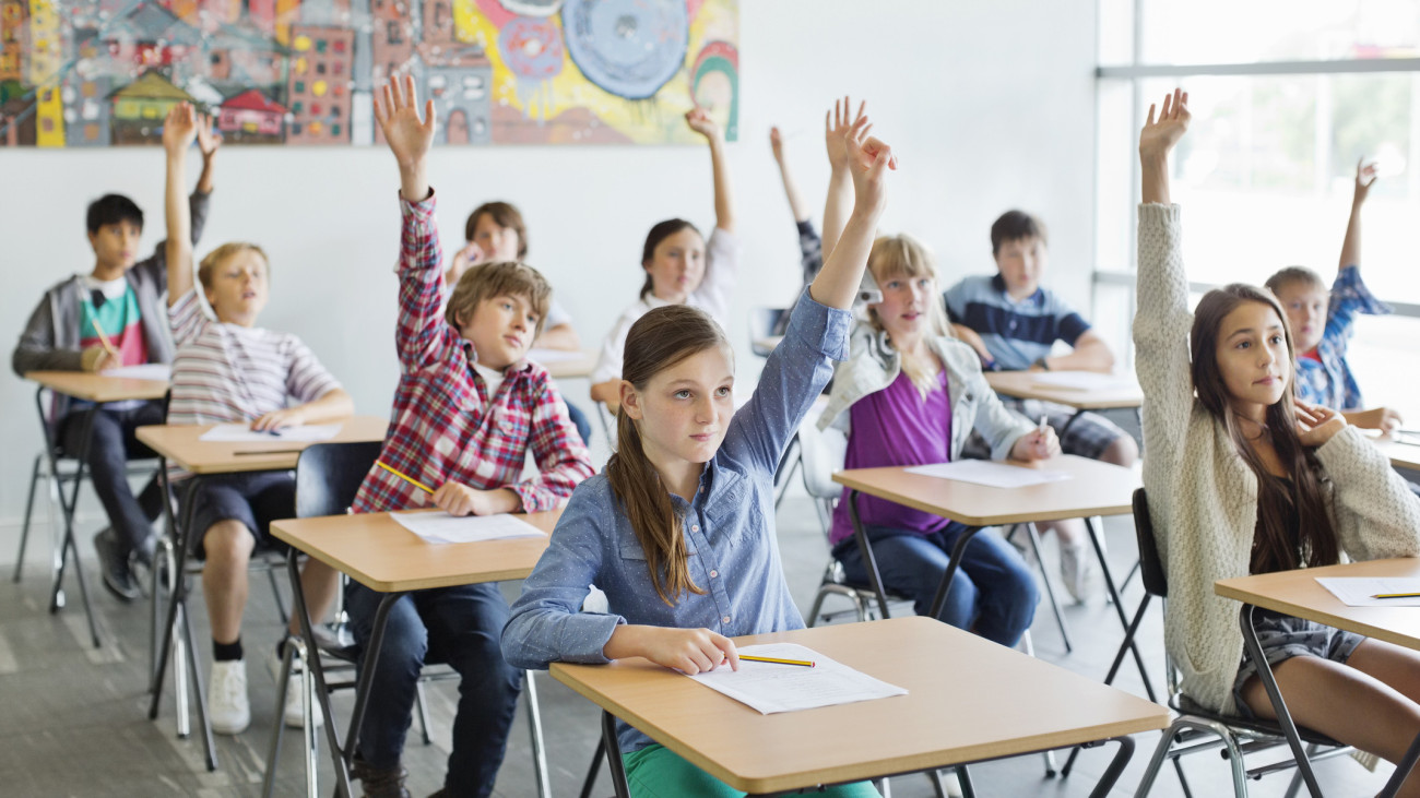 Students with arms raised in classroom