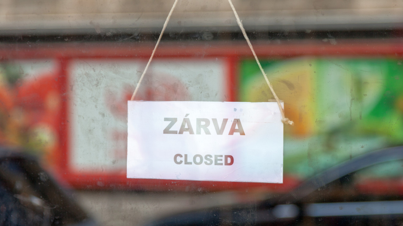 Old fashioned sign in the window of a shop saying in Hungarian ZĂĄrva, meaning in english Closed.