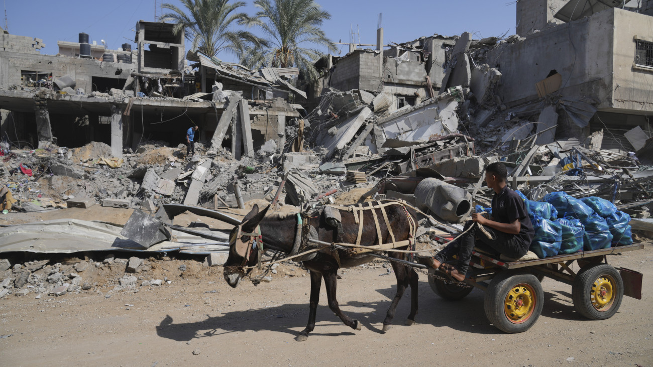 Izraeli légitámadás összedőlt ház romjai előtt egy palesztin férfi a Gázai övezet déli részén fekvő Deir el-Balahban 2023. október 25-én. A Gázai övezetet irányító Hamász palesztin iszlamista szervezet október 7-én többfrontos támadást indított Izrael ellen, az izraeli légierő azóta támadja a Hamász katonai létesítményeit a palesztinok lakta övezetben. Izraelben több mint 1400 ember életét vesztette, az izraeli válaszcsapások mintegy 5800 palesztin halálát okozták a Gázai övezetben.