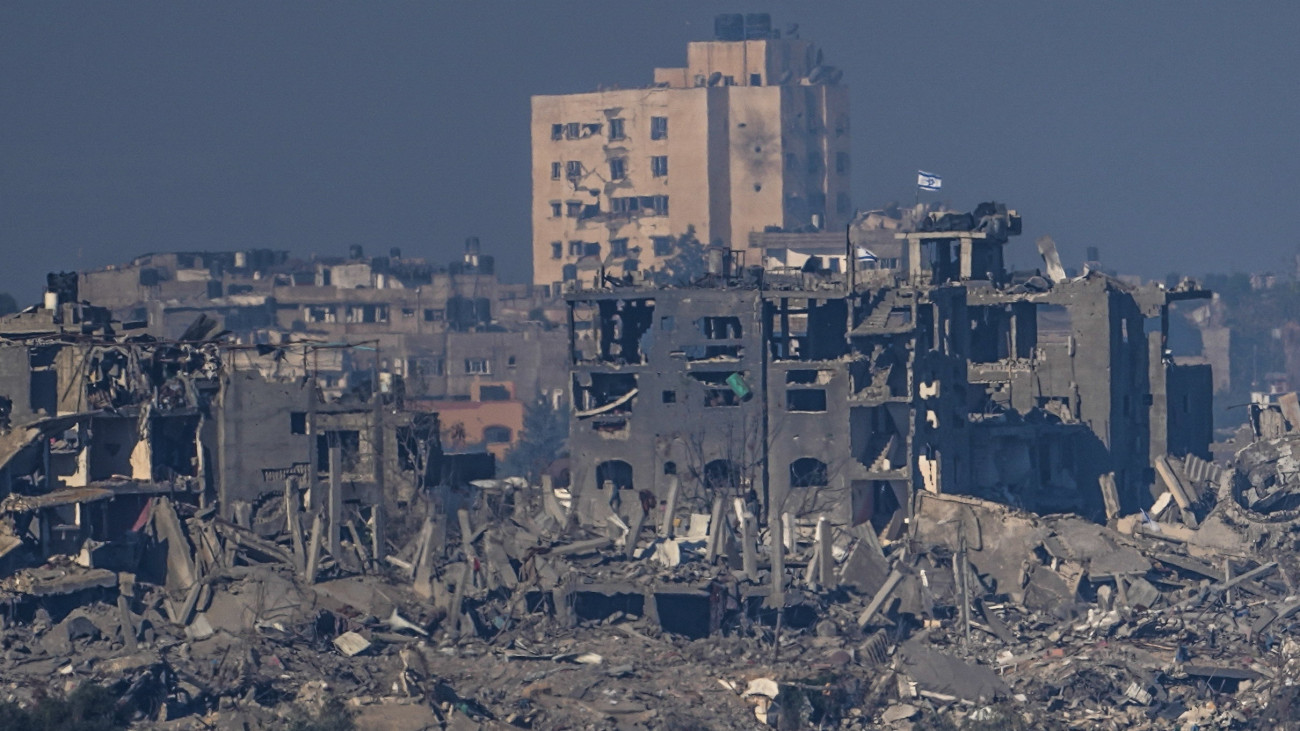 Izraeli zászló lobog az  egyik megrongálódott épületen a Gázai övezet egyik településén a dél-izraeli Szderótban készült képen 2023. november 18-án készített képen. A Hamász palesztin iszlamista szervezet fegyveresei október 7-én támadást indítottak Izrael ellen, az izraeli haderő pedig válaszul légi és szárazföldi hadműveleteket hajt végre a Gázai övezetben.