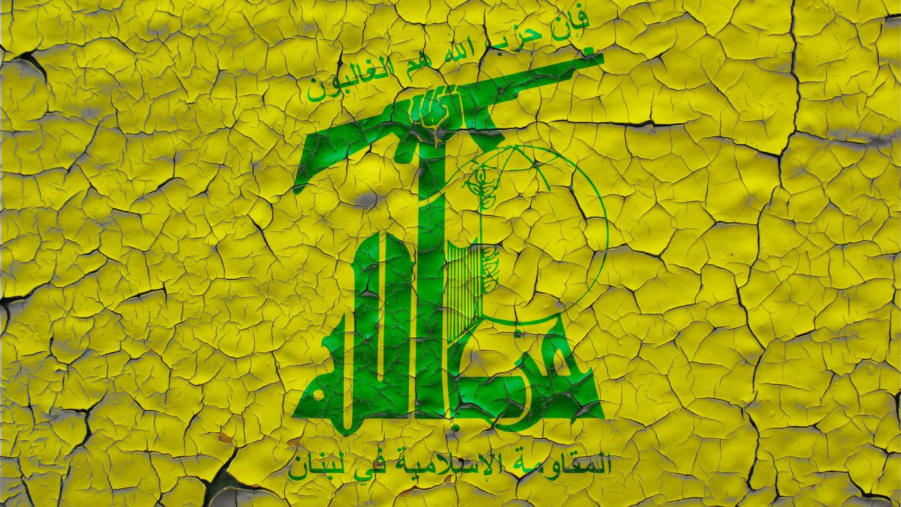 Hezbollah flags painted over cracked concrete wall