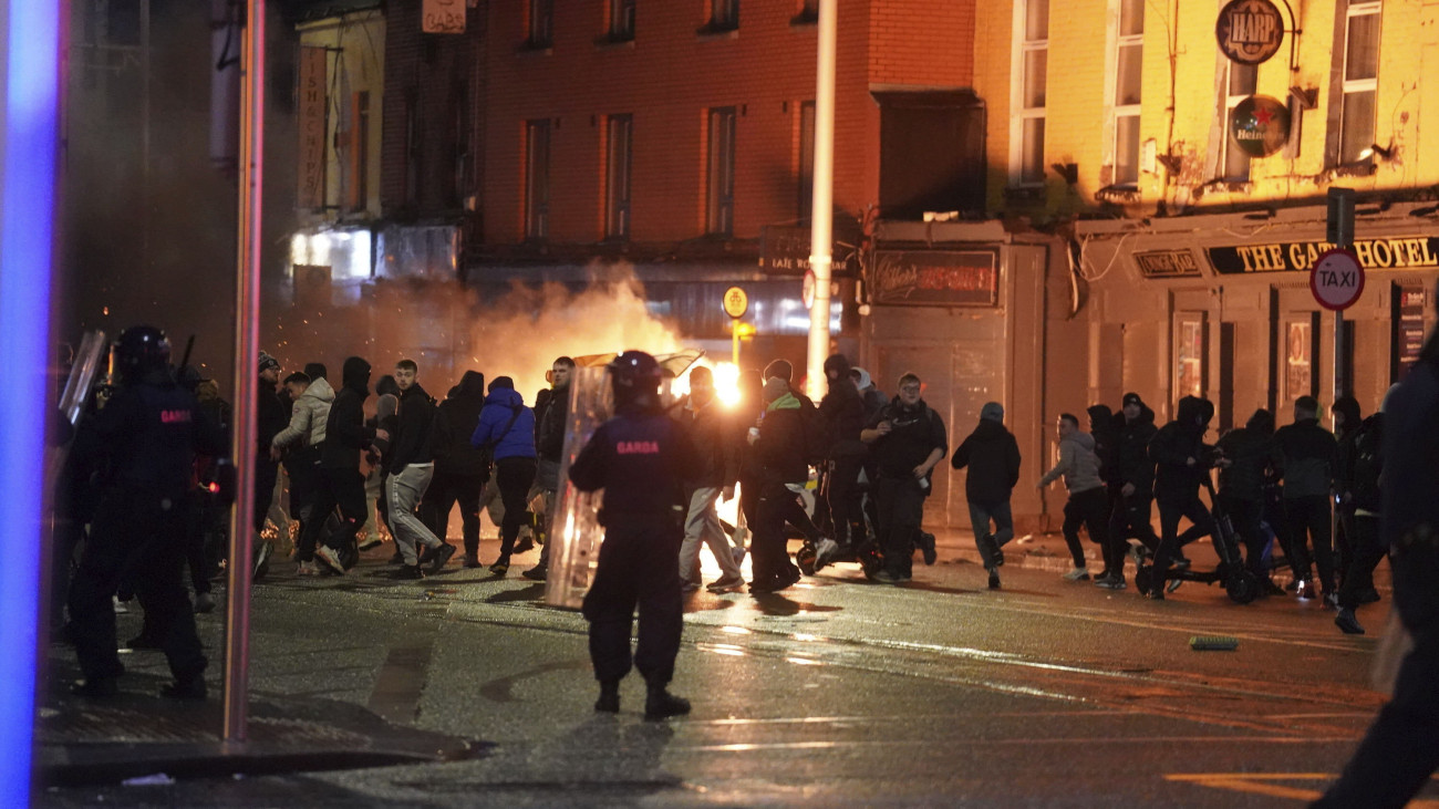 Rohamrendőrök rendbontókkal csapnak össze felgyújtott járműveknél Dublin belvárosában, ahol zavargások törtek ki egy késelés miatt 2023. november 23-án. Órákkal korábban egy férfi öt embert, köztük három gyermeket megsebesített, az egyiküket súlyosan. A rendőrség őrizetbe vette a feltételezett elkövetőt.