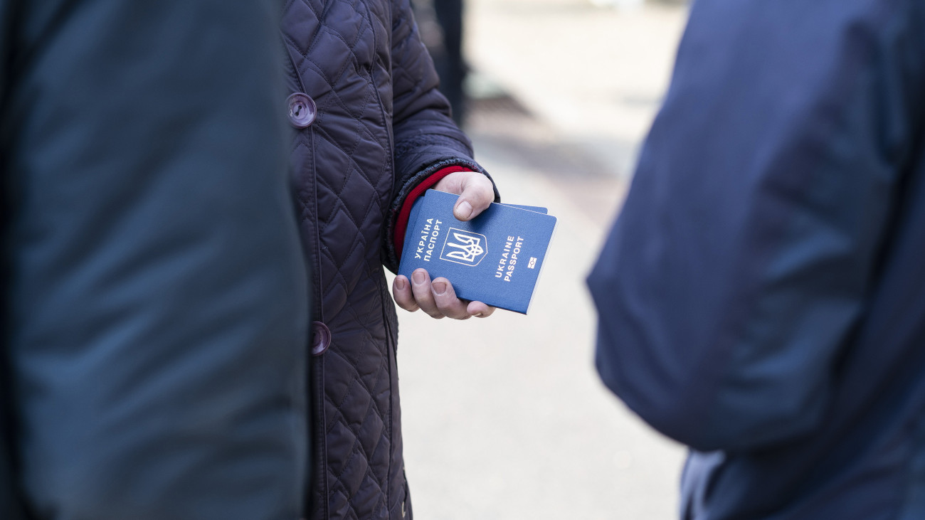 Az orosz-ukrán háború elől Ukrajnából menekülő ember tartja kezében útlevelét a záhonyi vasútállomáson 2022. március 7-én.