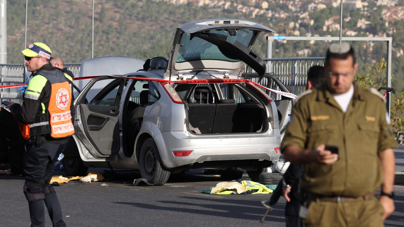 Az izraeli biztosnági szolgálat tagjai a Jeruzsálembe egyik bevezető útjánál elkövetett lövöldözés helyszínén 2023. november 30-án. Két felfegyverzett palesztin merénylő tüzet nyitott a buszmegállóban álló civilekre, egy 24 éves nő életét vesztette, öten súlyosan, egy ember közepesen, ketten pedig könnyebben megsebesültek, a támadókat a biztonságiak lelőtték.