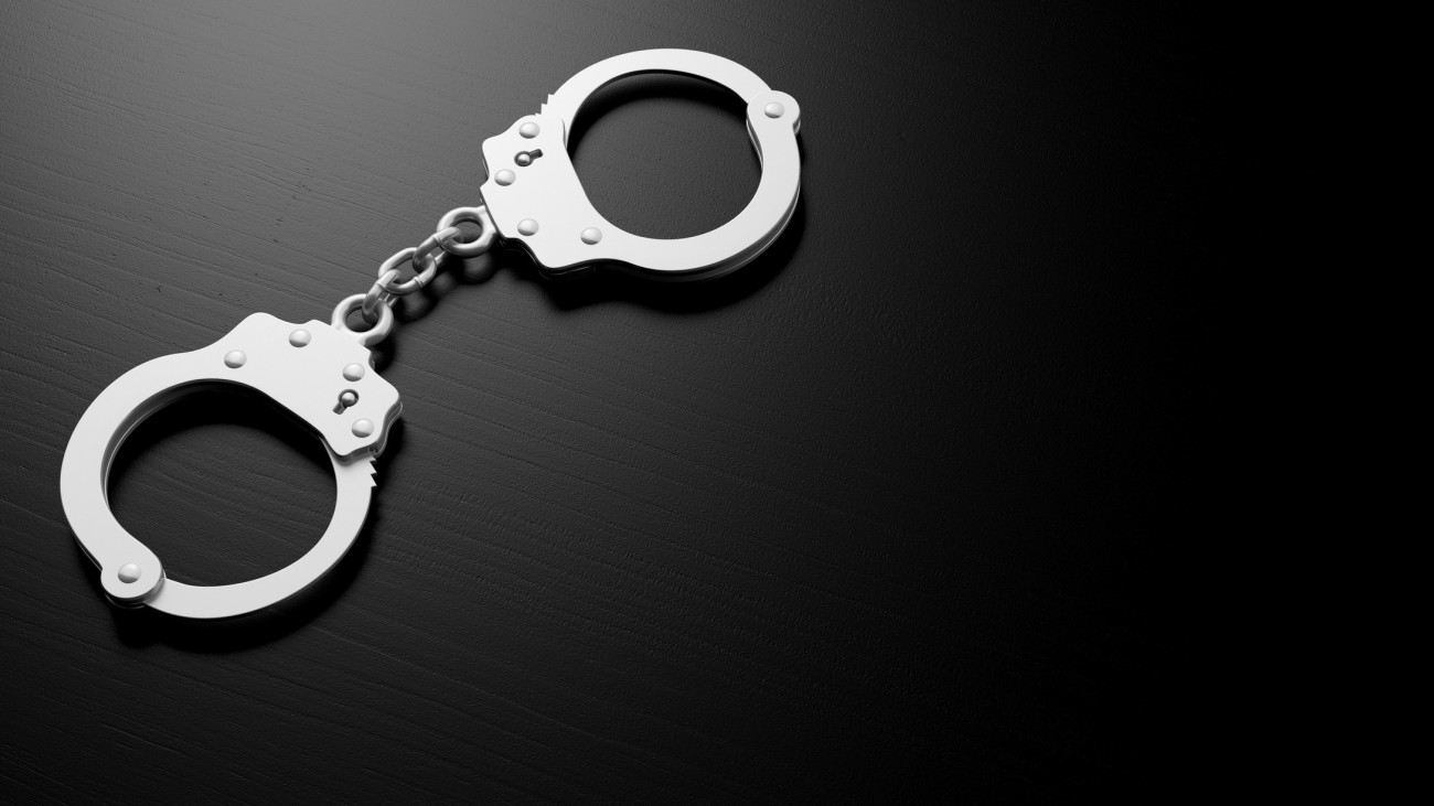 Metal police handcuffs isolated on black background, copy space, 3d illustration
