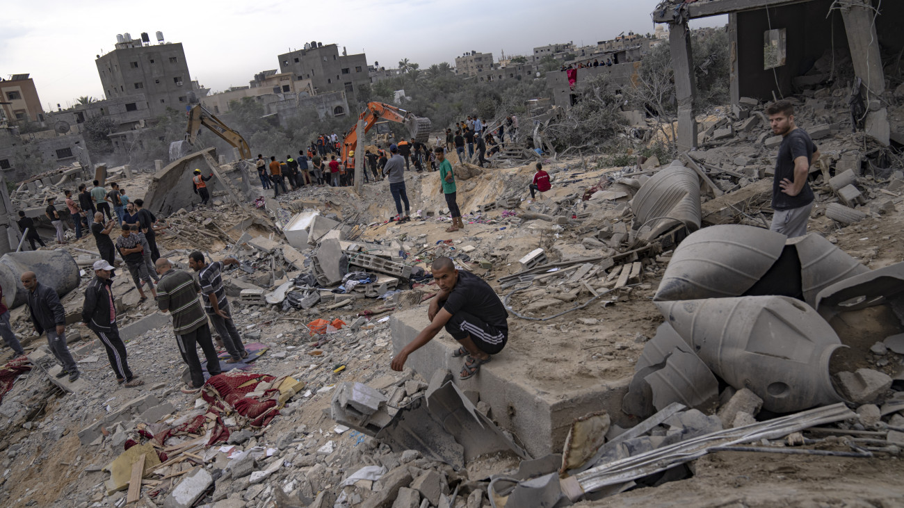 Palesztinok túlélők után kutatnak egy izraeli légicsapásban megsemmisült lakóépületek romjai között a Gázai övezet déli részén fekvő Hán-Júniszban lévő menekülttáborban 2023. november 12-én. A Gázai övezetet irányító Hamász palesztin iszlamista szervezet fegyveresei október 7-én támadást indítottak Izrael ellen, több mint 1400 embert meggyilkoltak, további mintegy háromezret megsebesítettek, valamint legalább 240 embert elraboltak, és túszként tartanak fogva. Palesztin vezetők szerint az izraeli válaszcsapások halálos áldozatainak száma átlépte a 11 078-at a palesztinok lakta területeken.