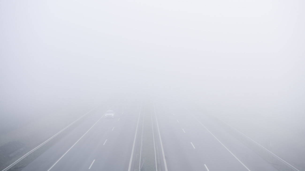Autó a sűrű ködben az M35-ös autópályán Debrecen közelében 2023. december 20-án.