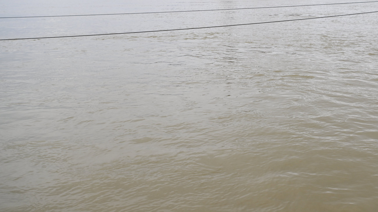 Az emelkedő vízállású Duna a lezárt Sztehlo Gábor rakpartról fotózva, szemben az Országház épülete 2023. december 25-én. A Duna felső szakaszán elkezdődött az árhullám tetőzése; Budapesten a folyó tetőzése december 27-én napközben várható, 660 centiméter körüli vízállással, elsőfokú árvízvédelmi készültség mellett.
