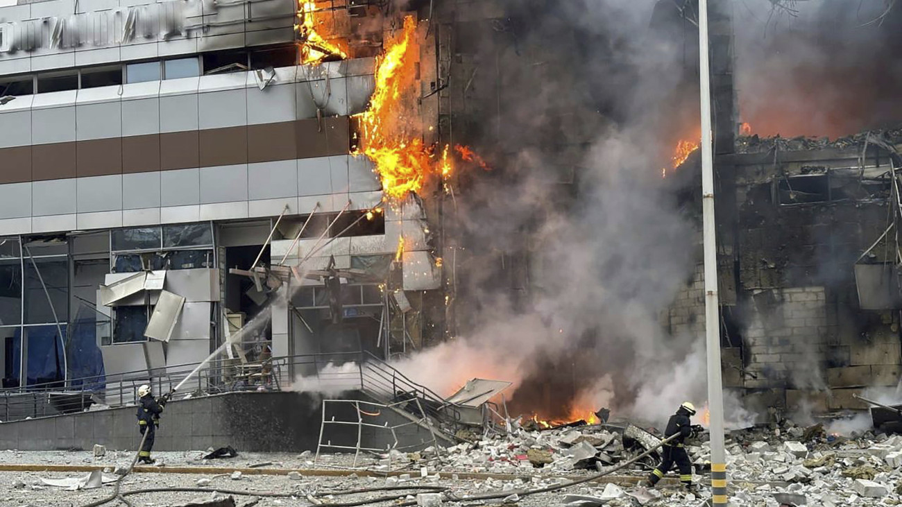 A vészhelyzetek ukrán állami szolgálata által közreadott, videófelvételről készített képen tűzoltók küzdenek a lángok megfékezésén egy orosz légitámadás következtében megsemmisült épületnél Kijevben 2023. december 29-én.