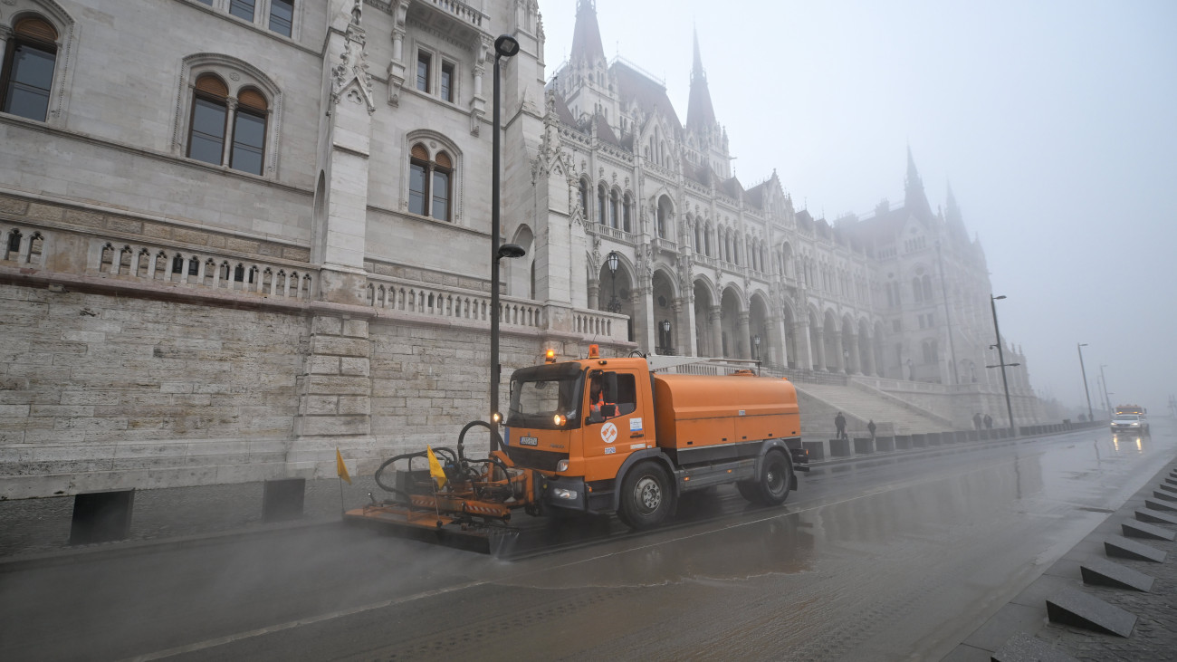 A Fővárosi Közterület-fenntartó Zrt. munkagépe takarítja a fővárosi idősebb Antall József rakpart Parlament előtti szakaszát a Dunán levonuló árhullám után 2023. december 30-án. A takarítás után a Budapest Közút Zrt. eltávolítja az alsó rakpartokra való lehajtást tiltó táblákat, így várhatóan december 31-én reggeltől mindkét alsó rakparton újra megindulhat a közlekedés.