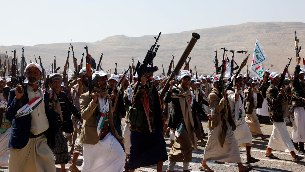 Amran, YEMEN - DECEMBER 20: Yemens Houthi loyalists lift their weapons as they take part in an armed parade for more than 20,000 members who have finished a military course, staged to show their willingness to battle any potential attack by the recently created coalition by the U.S., on December 20, 2023 in Amran province, Yemen. Yemens Houthi movement leader has warned that they would attack US ships in the Middle East if Washington waged war against them. (Photo by Mohammed Hamoud/Getty Images)
