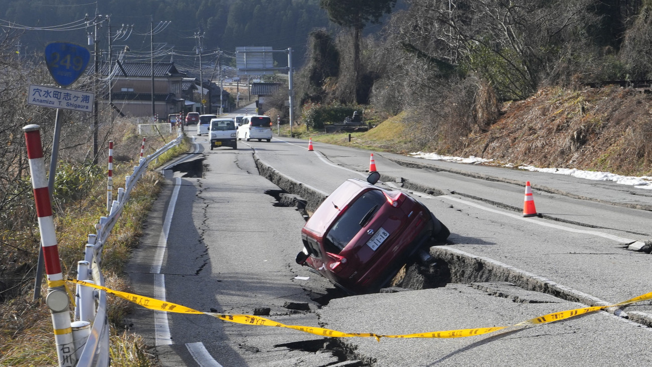 Autó egy beszakadt úttest résében az Isikava prefektúrában lévő Anamizu város közelében 2024. január 2-án, egy nappal a Japán középső részét megrázó, 7,6-os erősségű földrengés után. Az első rengést több utórengés követte: összesen huszonegy, négyesnél nagyobb erősségű földmozgást észleltek. A szigetországban szökőárriadót adtak ki.