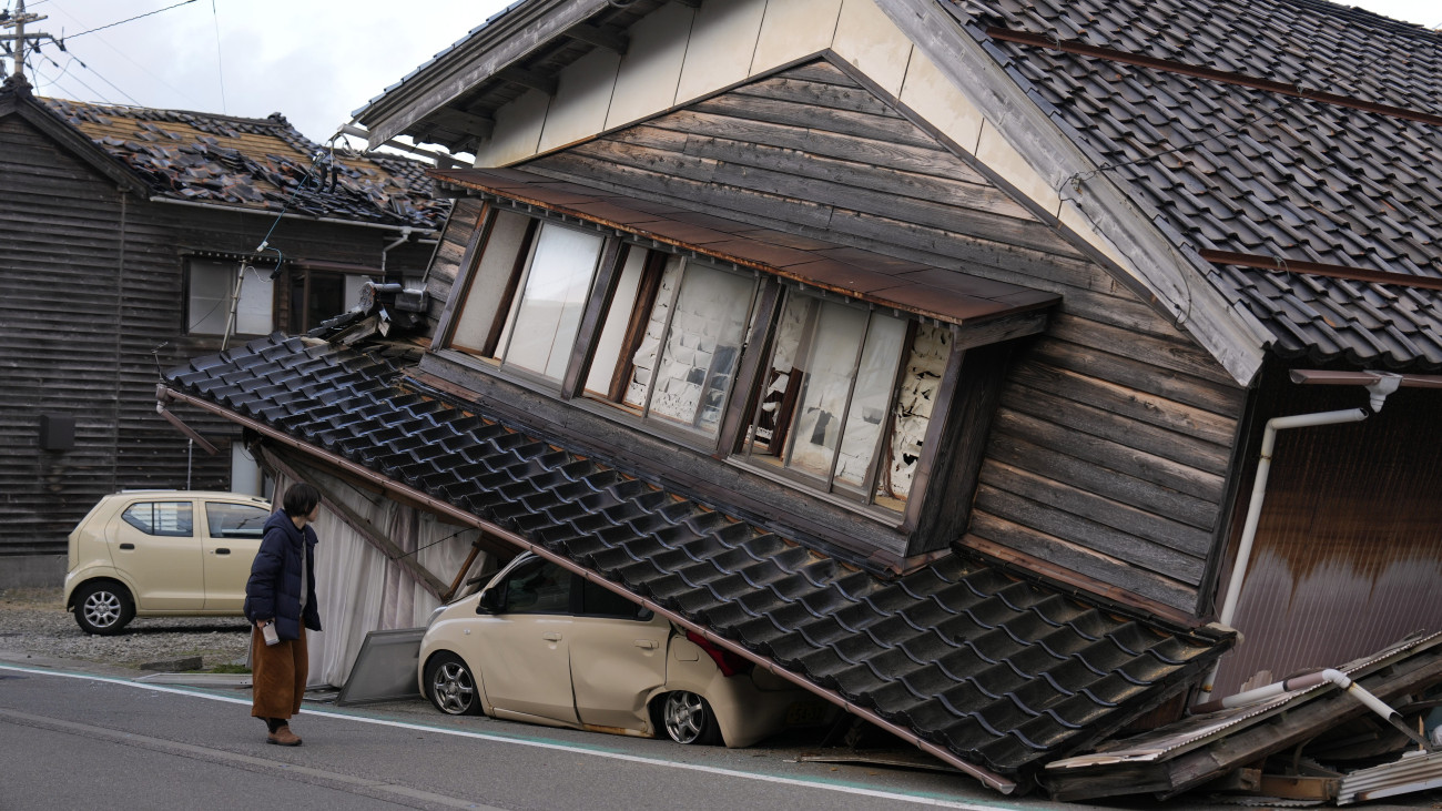 Összedőlt lakóházát nézi egy helyi lakos az Isikava prefektúrában lévő Togi városban 2024. január 2-án, egy nappal a Japán középső részét megrázó, 7,6-os erősségű földrengés után. Az első rengést több utórengés követte: összesen huszonegy, négyesnél nagyobb erősségű földmozgást észleltek. A szigetországban szökőárriadót adtak ki. A természeti katasztrófa következtében legkevesebb 48 ember életét vesztette, 17-en súlyosan megsebesültek.