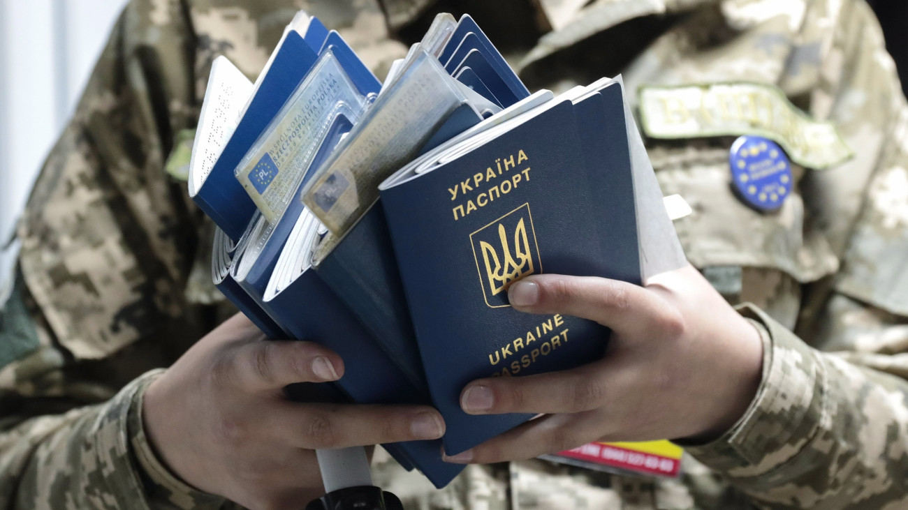 Lviv, 2017. június 11.Útleveleket ellenőriz egy ukrán határőr az ukrán-lengyel határ Rava-Ruska átkelőhelyén, az ukrajnai Lviv közelében 2017. június 11-én. Ezen a napon életbe lépett az ukrán állampolgárok európai uniós vízummentessége, Ukrajna biometrikus útlevéllel rendelkező állampolgárai ezentúl vízum nélkül utazhatnak az Európai Unió tagállamaiba. (MTI/EPA/Pavlo Palamarcsuk)