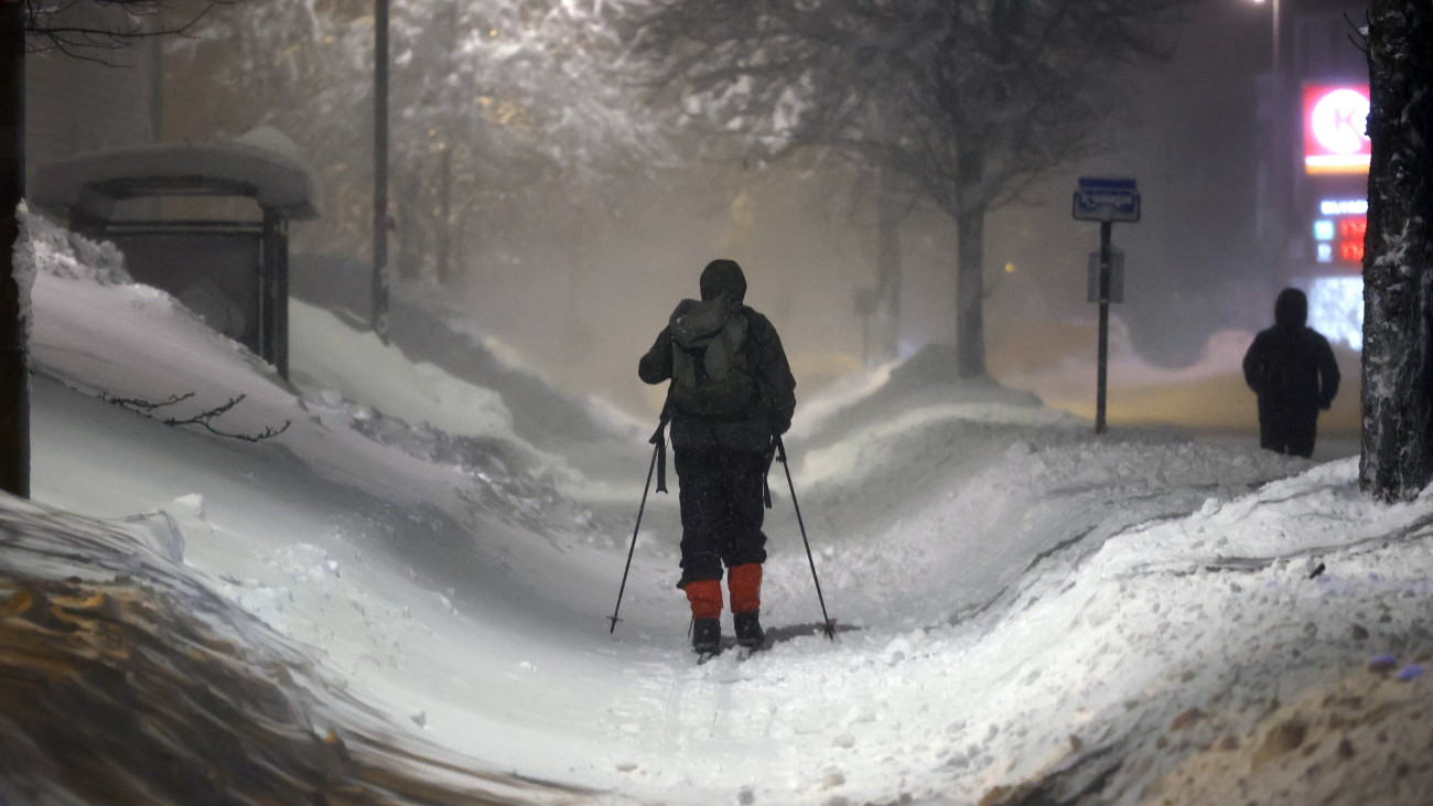 Síléccel közlekedő férfi egy vastag hótakaróval borított utcán a norvégiai Kristiansandban 2024. január 3-án. A hóviharok miatt iskolákat zártak be, buszjáratokat töröltek Norvégiában. Európa sarkvidéki részein akár mínusz 40 Celsius-fokra is süllyedhet a hőmérséklet.