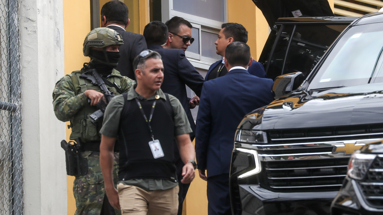 Daniel Noboa ecuadori elnök (k) távozik a Canela rádióállomás stúdiójából, ahol beszédet intézett a nemzethez Quitóban 2024. január 10-én. Noboa január 8-án hatvannapos szükségállapotot és országos éjszakai kijárási tilalmat rendelt el a kábítószer-kereskedelmet irányító bűnbandák, valamint az utcai és a börtönökben dúló erőszak visszaszorítása céljából, másnap pedig 22 bandát nevezett meg terrorista szervezetként, hivatalos katonai célponttá téve őket.