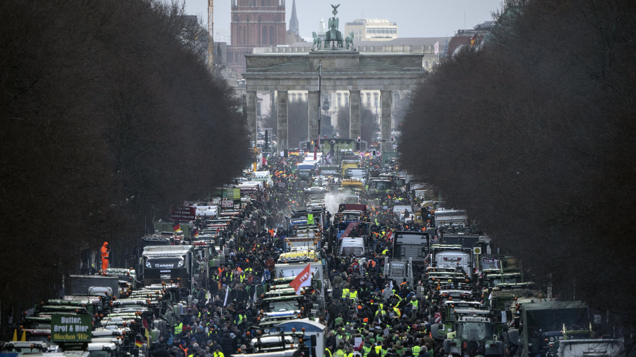 Tüntető gazdálkodók traktorokkal és járművekkel a berlini Június 17. úton, a háttérben a Brandenburgi kapu 2024. január 15-én. A parasztgazdák a mezőgazdasági adókedvezmények jelentős csökkentése miatt tiltakoznak.