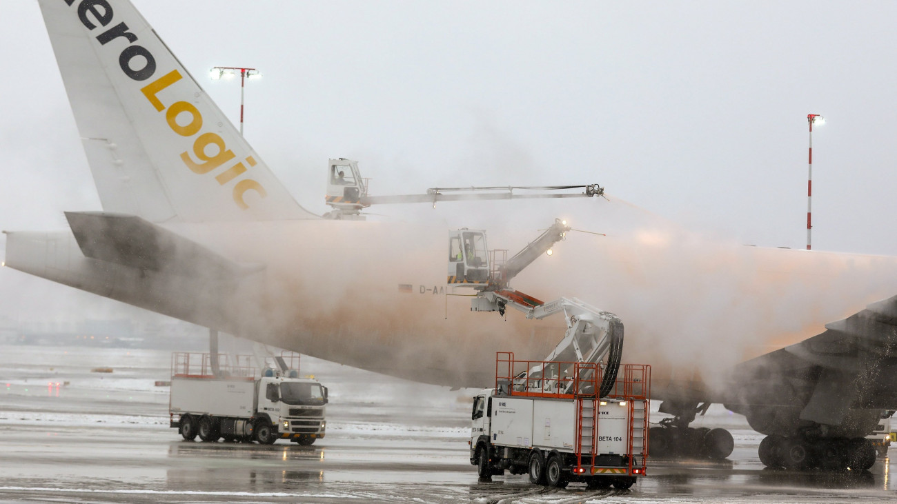 Frankfurt, 2017. december 18.Jegesedést gátló réteggel vonnak be egy utasszállító repülőgépet a havas Frankfurti Nemzetközi Repülőtéren 2017. december 18-án. Számos járat késve indul a légi járművek jégmentesítése miatt, a repülőtér üzemeltetője több mint 170 járatot törölt. (MTI/EPA/Jörg Halisch)