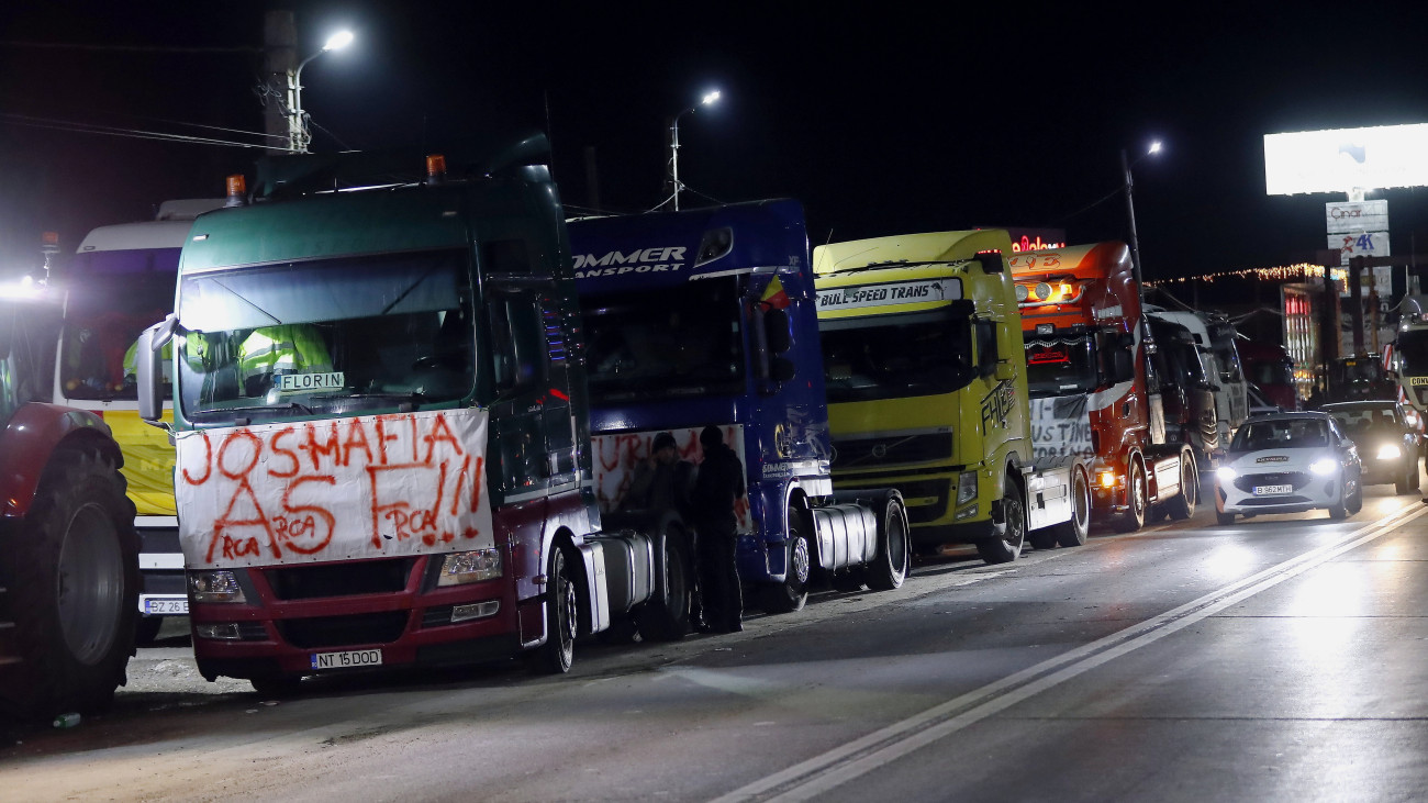 Mezőgazdasági termelők és teherautósofőrök traktorjaikkal lassítják a forgalmat a Bukaresttől 20 kilométerre északkeletre fekvő Afumatiban 2024. január 16-án Romániában. A tüntetők a kötelező gépjármű-felelősségbiztosítások (KGFB) drágulása és az üzemanyag jövedéki adójának növekedése, valamint az ukrán gabonaimport következményei ellen tiltakoznak.