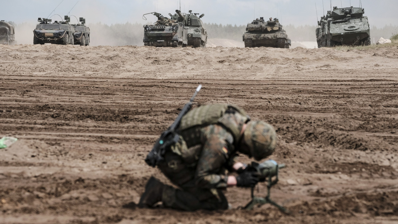 Német katona páncélozott katonai járművek előtt a Griffin Storm 2023 fedőnevű litván-német NATO-hadgyakorlaton a Vilniustól mintegy 60 kilométerre, északra fekvő Pabrade gyakorlóterén 2023. június 26-án. A manőverek kezdetén jelen lévő német védelmi miniszter bejelentette: Németország négyezer katonát küld Litvániába állandó jelleggel a NATO keleti szárnya megerősítésének érdekében.
