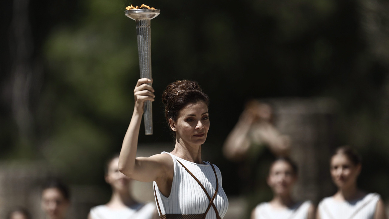 Olümpia, 2016. április 21.A főpapnő szerepét játszó Katerina Lehu a fáklyát fogja az olimpiai láng fellobbantási ünnepségén Héra templománál, az eredeti olimpiai játékok helyszínén, az ókori Olümpiában 2016. április 21-én. Az ünnepség végén a lángot szállító staféta elindul a 2016-os nyári olimpiának otthont adó Rio de Janeiro felé. A lángot a hagyományok szerint a nap sugarait összegyűjtő konkáv tükör segítségével lobbantják fel. (MTI/EPA/Jánisz Koleszidisz)