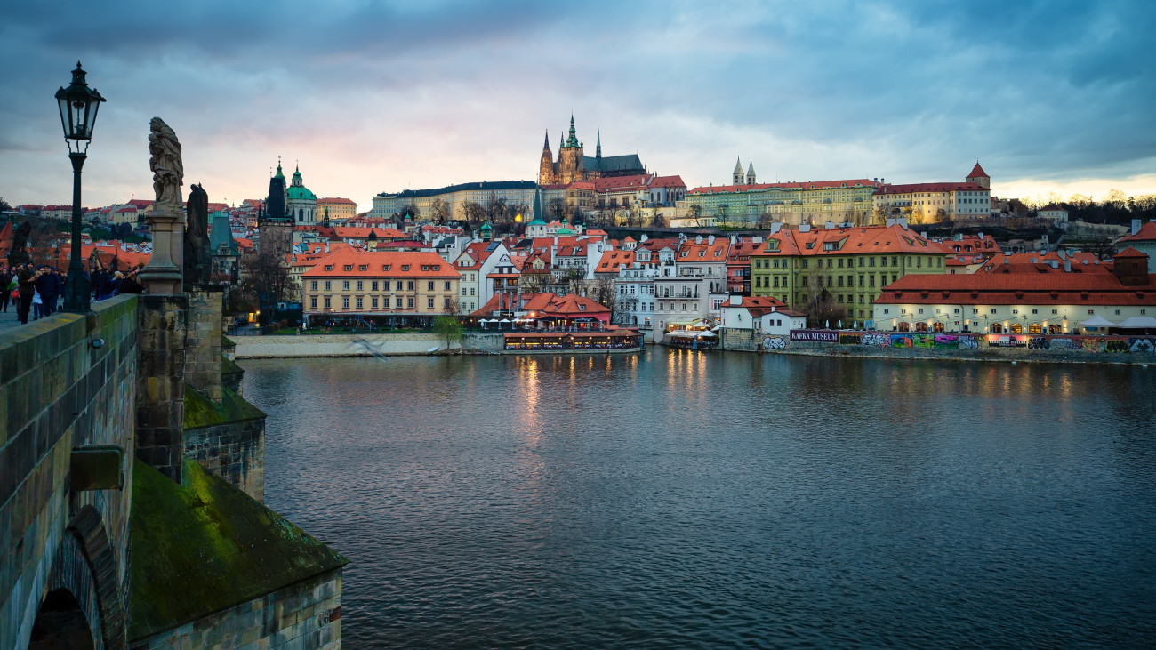 This image was captured at Prague, the capital city of Czech. The bridge on left side is famous Charles bridge built on Vltava river. The building in the middle is Prague town hall, standing on a high place across the river.