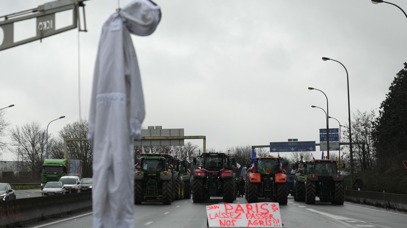 Tüntető francia gazdák traktorai torlaszolnak el egy autópályát Párizs Chilly-Mazarin nevű déli elővárosánál 2024. február 1-jén, amikor Gabriel Attal miniszterelnök újabb intézkedéseket jelentett be a két hete tüntető gazdák terheinek enyhítésére.