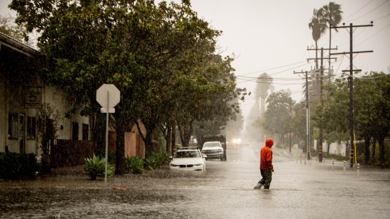 Egy férfi megy az árvízzel elöntött utcák egyikén a kaliforniai Santa Barbarában 2024. február 4-én. Kalifornia óceáni partvidékén csaknem 370 ezer háztartás maradt áram nélkül a térséget elért, jelentős széllel és súlyos esőzéssel járó viharzóna miatt.