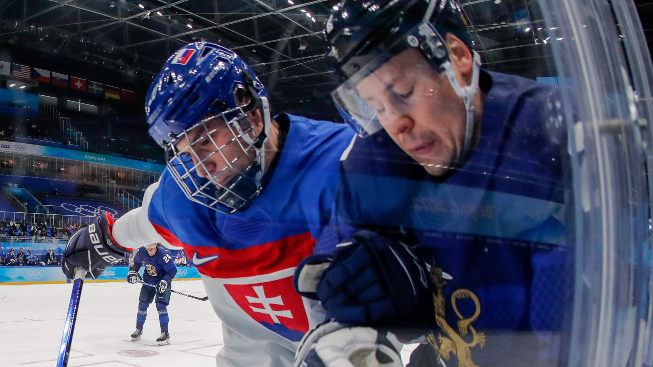 A szlovák Juraj Slafkovsky (b) és a finn Ville Pokka a 2022-es téli olimpia férfi jégkorongtorna elődöntőjében játszott Finnország  Szlovákia mérkőzésén a pekingi Fedett Stadionban 2022. február 18-án.