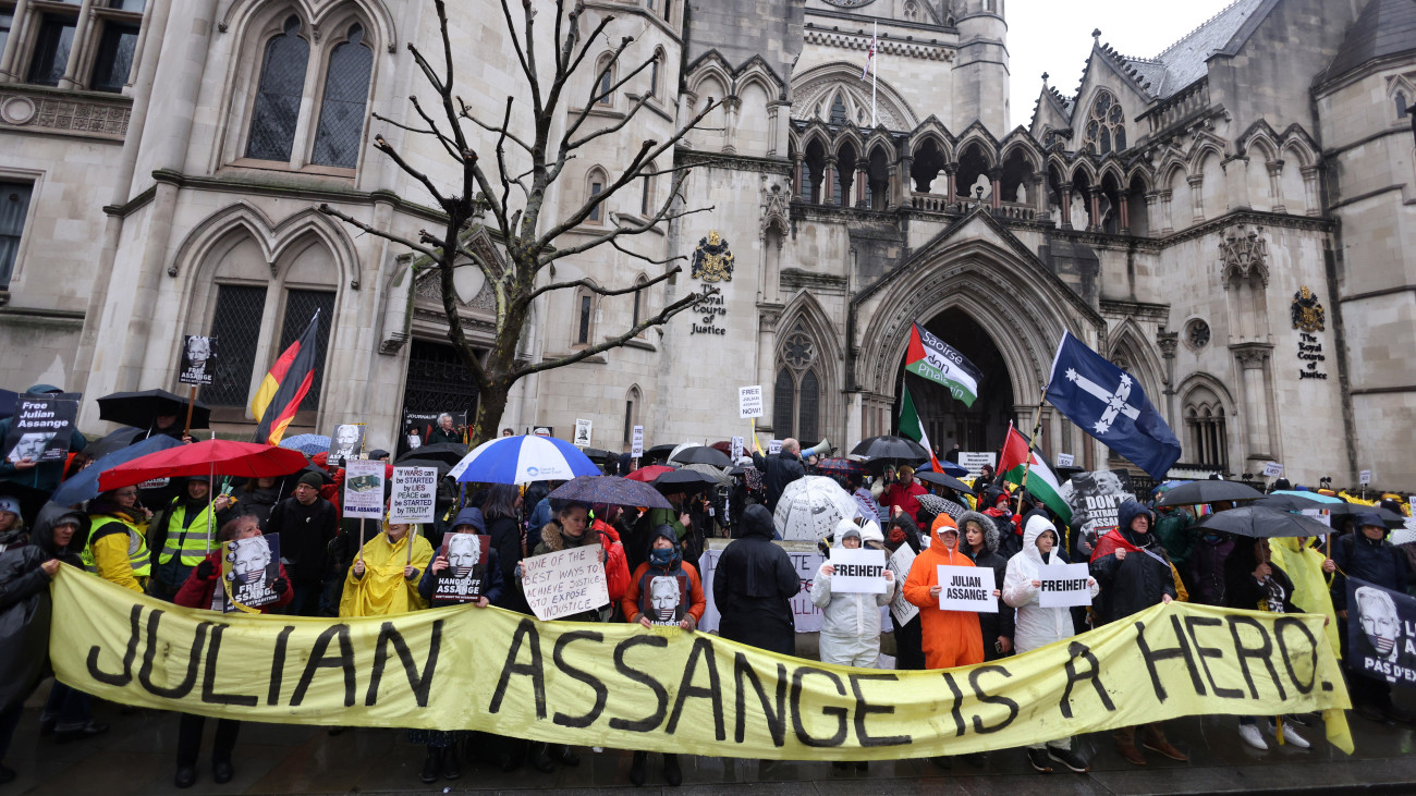 Julian Assange-nak a WikiLeaks oknyomozó internetes portál ausztrál alapítójának kiadatása ellen tüntetnek a brit legfelsőbb bíróság londoni épülete előtt 2024. február 21-én, amikor folyatódik a bíróságon a tárgyalás Assange kiadatásáról az Egyesült Államoknak. A felirat szerint Assange hős. A kiadatást kérelmező amerikai hatóságok Assange ellen 18 vádpontot fogalmaztak meg, ezek közül 17 kémkedéssel, egy pedig számítógépes rendszerek feltörésével vádolja a férfit.