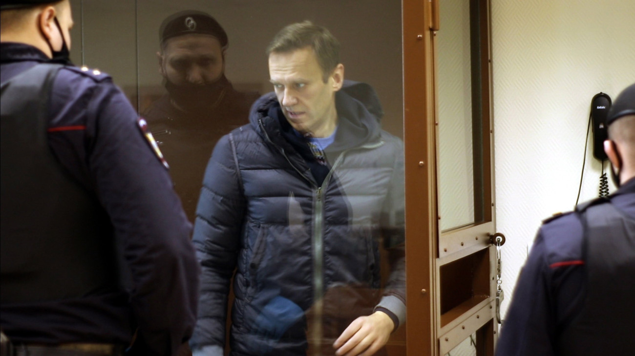 A Babuskinszkij kerületi bíróság által közreadott videóról készített felvételen Alekszej Navalnij orosz ellenzéki politikus meghallgatásra érkezik a bíróság moszkvai tárgyalótermébe az ellene rágalmazás vádjával indított perben 2021. február 16-án. Navalnij lakájoknak, árulóknak és az ország szégyenének nevezte Ignat Artyomenko második világháborús orosz veteránt és másokat, akik szerepeltek egy, az előző évi alkotmánymódosítás mellett agitáló reklámfilmben.
