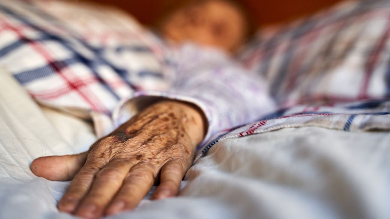 Close-up hand of hispanic senior woman illness with cancer convalescing on bed in hospital lying on her bed. Healthcare and medicine concept. Cancer patient in hospital bed. Horizontal photography.