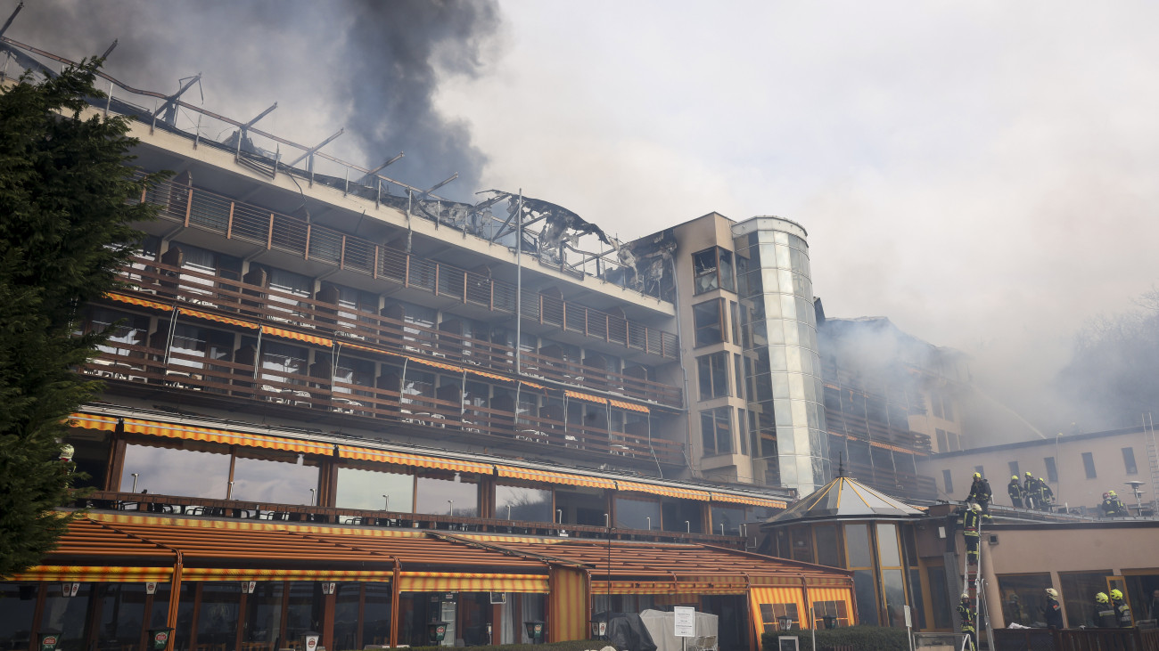 Tűzoltók oltják a kigyulladt visegrádi Hotel Silvanus épületét 2024. március 9-én. A hotel felső szintje teljes terjedelmében kiégett, a vendégek elhagyták az épületet.