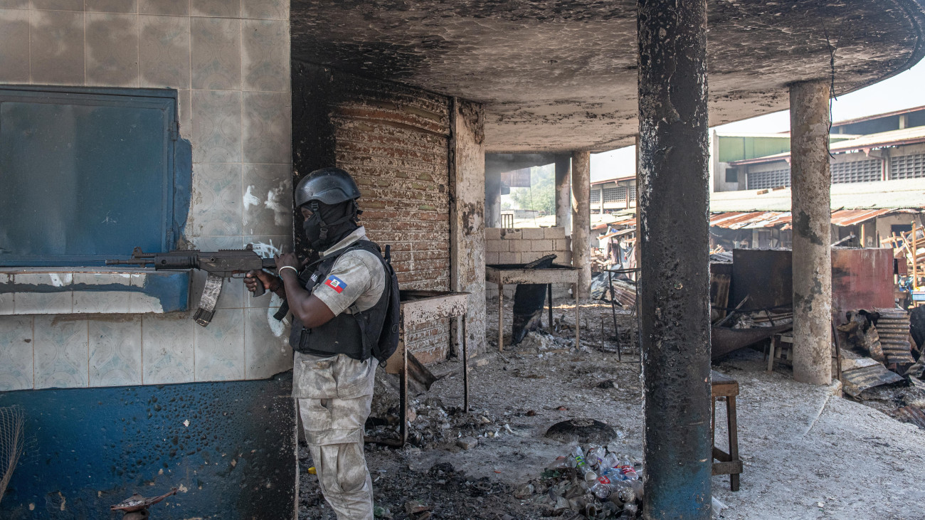 Célra tart egy rendőr a külföldön tartózkodó Ariel Henry ügyvivő miniszterelnök lemondását követelő tüntetésen a haiti fővárosban, Port-au-Prince-ban 2024. március 7-én. A hatóságok meghosszabbították a szükségállapotot és a kjárási tilalmat, hogy úrrá lehessenek a fővárost megbénító erőszakhullámon. Mára Port-au-Prince területének nagyjából 80 százaléka került bűnbandák kezére, akik rettegésben tartják a lakosságot.