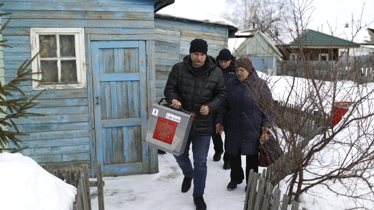 Mozgóurnát visznek egy választási bizottság tagjai az orosz elnökválasztáson a szibériai Omszk környékén fekvő faluban, Nyikolajevkában 2024. március 16-án. A választást március 15-17. között rendezik Oroszországban.