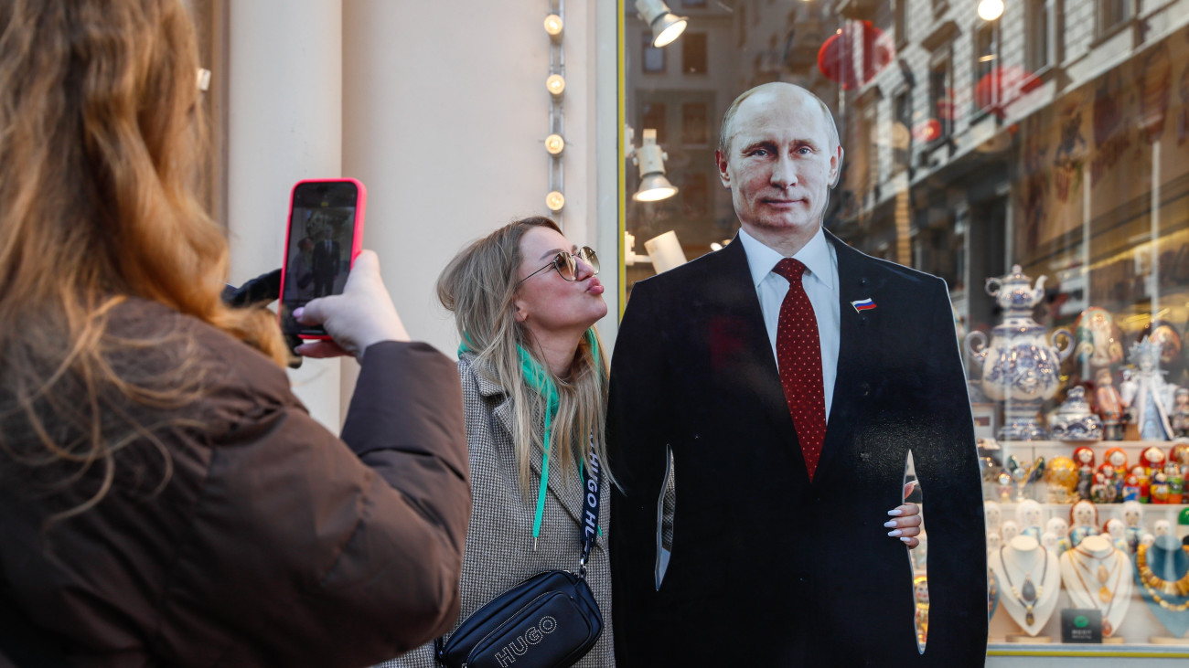 Vlagyimir Putyin orosz elnök kartonfigurájával fényképezkedik egy nő Moszkvában 2024. március 13-án. Az elnökválasztást március 15-17-én tartják Oroszországban.