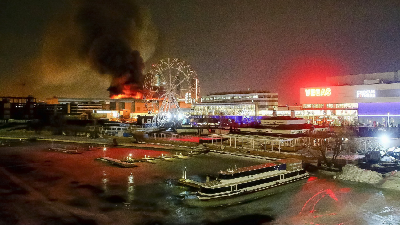 Füst száll fel a lángoló moszkvai Crocus City Hall nevű hangversenyteremből, amelyben katonai terepruhát viselő fegyveresek tüzet nyitottak Krasznogorszkban 2024. március 22-én. Az épületben tűz ütött ki, a támadásnak halottjai és sebesültjei is vannak.
