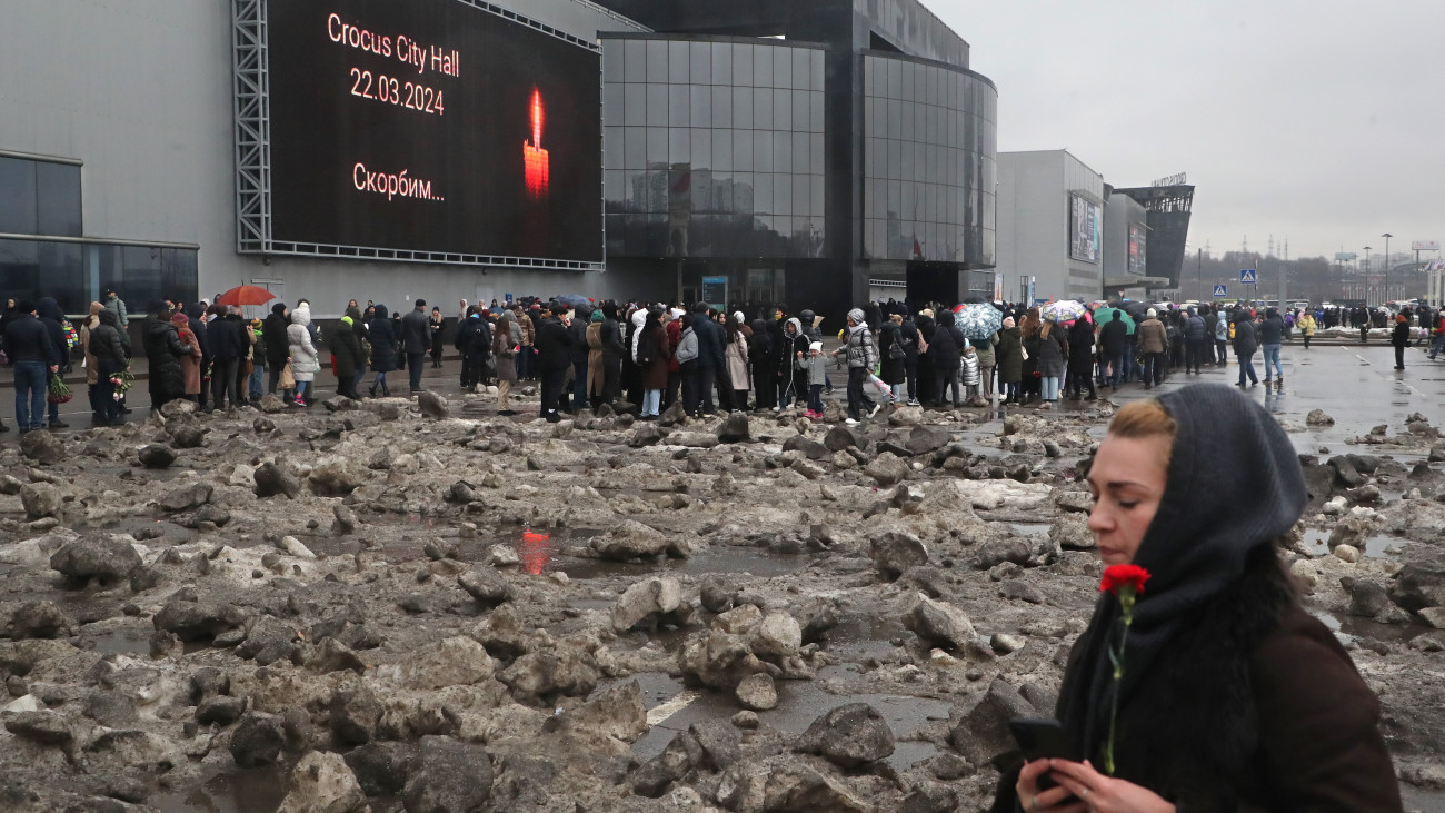 Gyászolók a Crocus City Hall kulturális központnál, Moszkva Krasznogorszk nevű nyugati elővárosában 2024. március 24-én. Két nappal korábban fegyveresek terrortámadást követtek el az épületben egy koncert előtt, a halálos áldozatok száma 137-re emelkedett, 180-an megsérültek. A merénylet négy végrehajtóját elfogták, és az orosz Nyomozó Bizottság (SZK) moszkvai székházába szállították. Az ügyben további hét gyanúsítottat vettek őrizetbe. Oroszországban nemzeti gyásznapot hirdettek március 24-re.