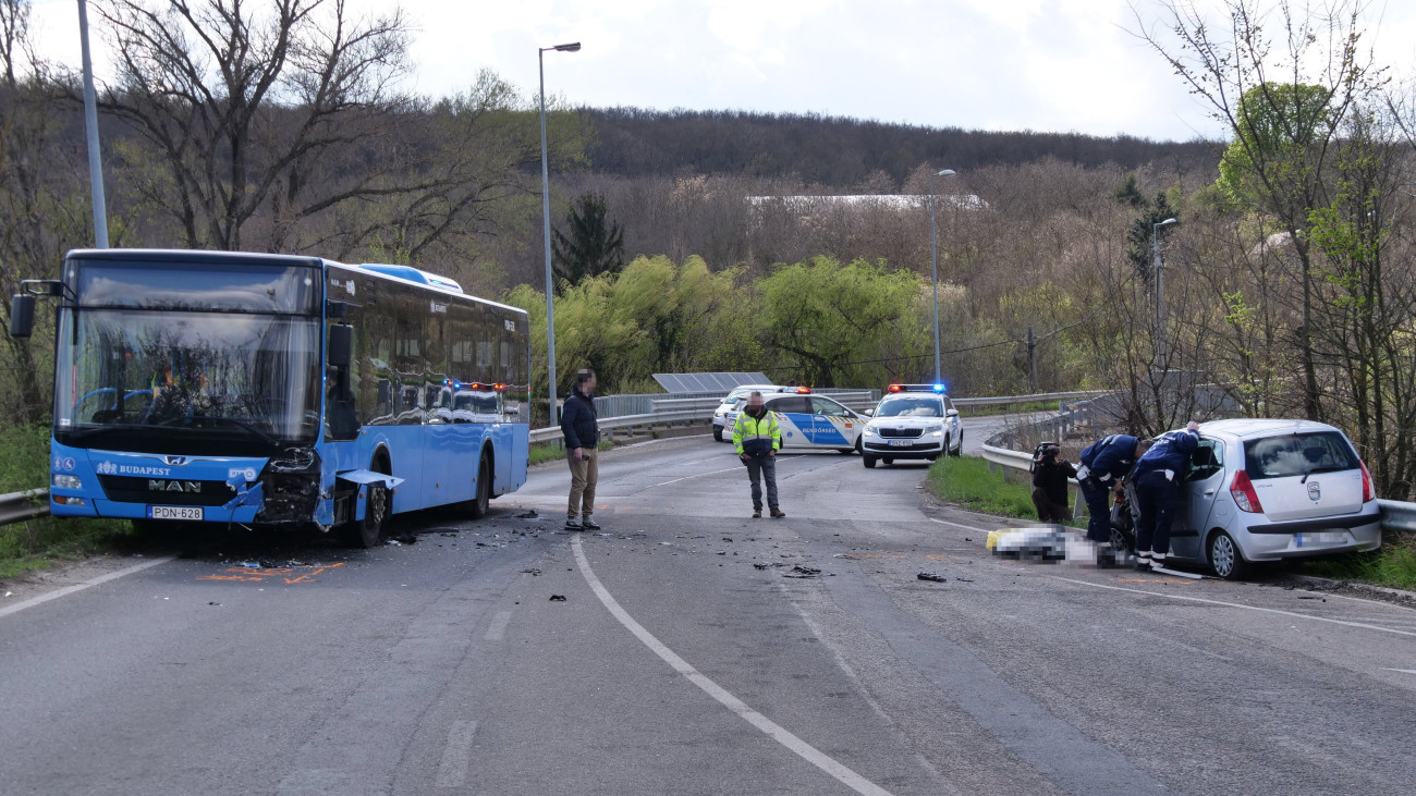 Sérült autóbusz Budapest XI. kerületében a Balatoni úton, ahol a busz egy személyautóval (jobbra) ütközött össze 2024. március 25-én. A balesetben egy ember meghalt.