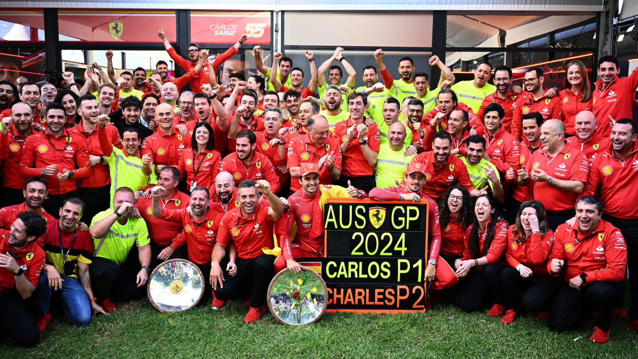 A futamgyőztes Carlos Sainz, a Ferrari spanyol versenyzője (táblánál balra) és második helyezett monacói csapattársa, Charles Leclerc (táblánál jobbra) ünnepel a csapattal a Forma-1-es autós gyorsasági világbajnokság Ausztrál Nagydíjának futama után a melbourne-i Albert Park versenypályán 2024. március 24-én.