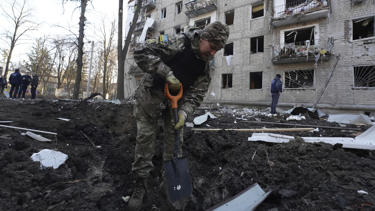 Orosz légitámadásban keletkezett bombatölcsér mellett egy rendőr a kelet-ukrajnai Harkivban 2024. március 27-én. A polgármester szerint egy ember életét vesztette, tizenhat pedig megsebesült.
