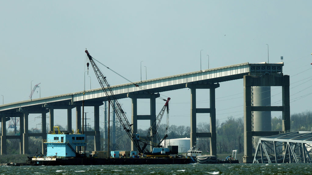 BALTIMORE, MARYLAND - MARCH 29: A crane is moved into position to help clear debris from the Francis Scott Key Bridge on March 29, 2024 in Baltimore, Maryland. The bridge collapsed on Tuesday at 1:30AM, after being struck by the massive cargo ship Dali. Two members of a road repair crew were pulled from the Patapsco River immediately after the collision, while two other bodies were pulled from the water on Wednesday and four people remain missing and are presumed dead after the Coast Guard called off rescue efforts. The accident has temporarily closed the Port of Baltimore, one of the largest and busiest on the East Coast of the U.S. (Photo by Kevin Dietsch/Getty Images)