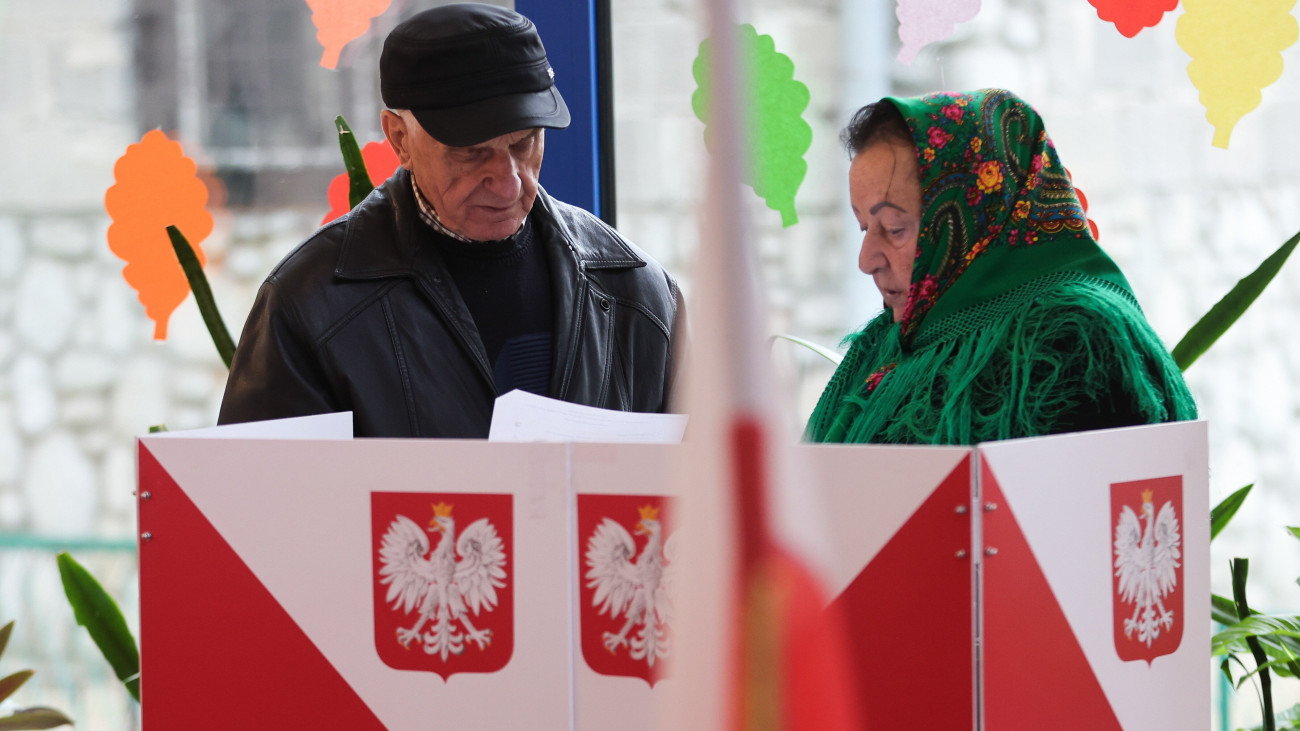 Tátrai házaspár szavaz a lengyel parlamenti választásokon a Zakopane közelében fekvő faluban, Zabban 2023. október 15-én. A választásokkal egy időben népszavazást is rendeznek az Európai Unió migrációs csomagjáról, az állami vagyon privatizációjáról, a nyugdíjkorhatárról, valamint a fehérorosz határon emelt acélkerítésről.