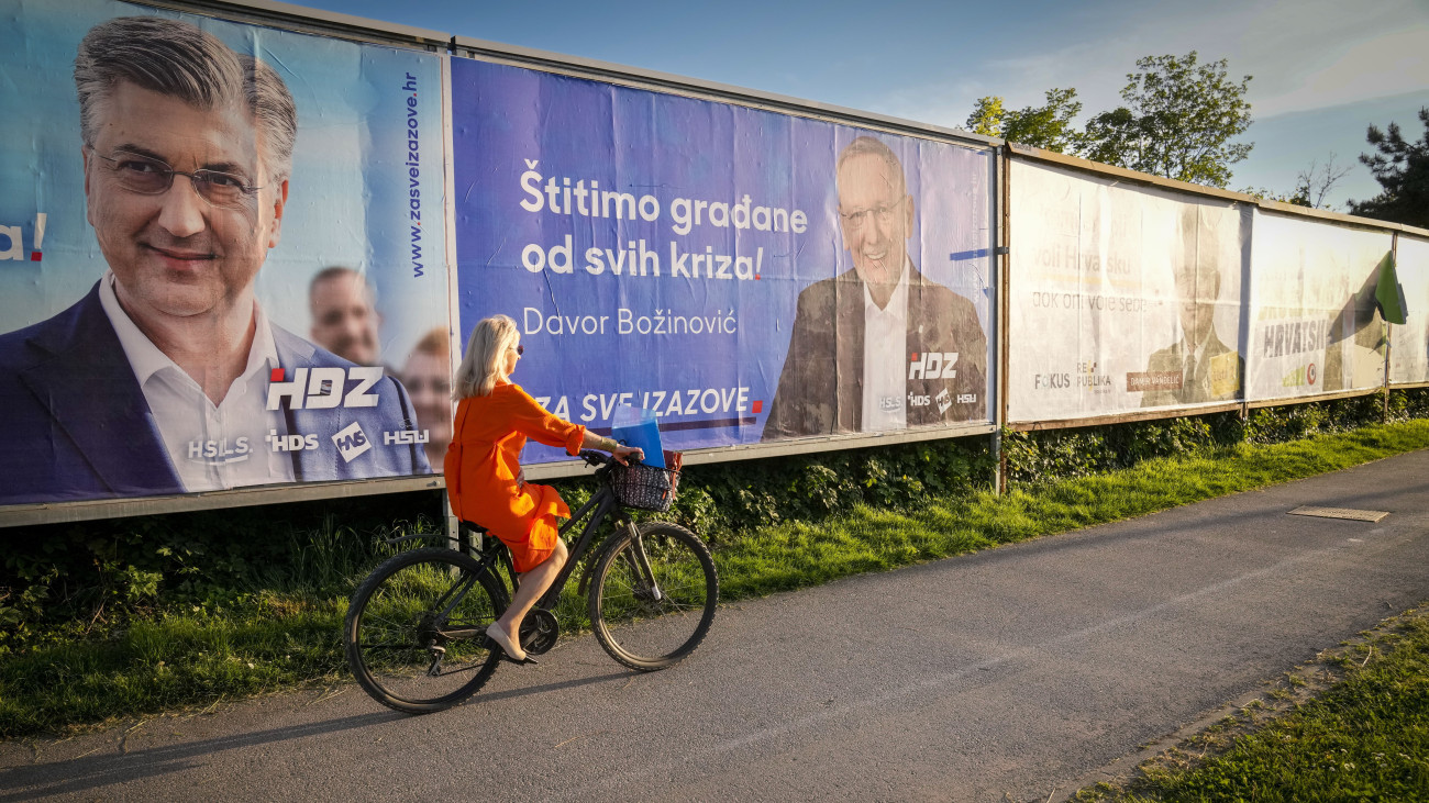 Kerékpáros Andrej Plenkovic horvát miniszterelnököt (b), valamint Davor Bozinovic kormányfőhelyettes és belügyminisztert, a kormányzó jobboldali Horvát Demokratikus Közösség (HDZ) politikusait ábrázoló kampányplakátok mellett Zágrábban 2024. április 14-én. Horvátországban április 17-én parlamenti választásokat tartanak.