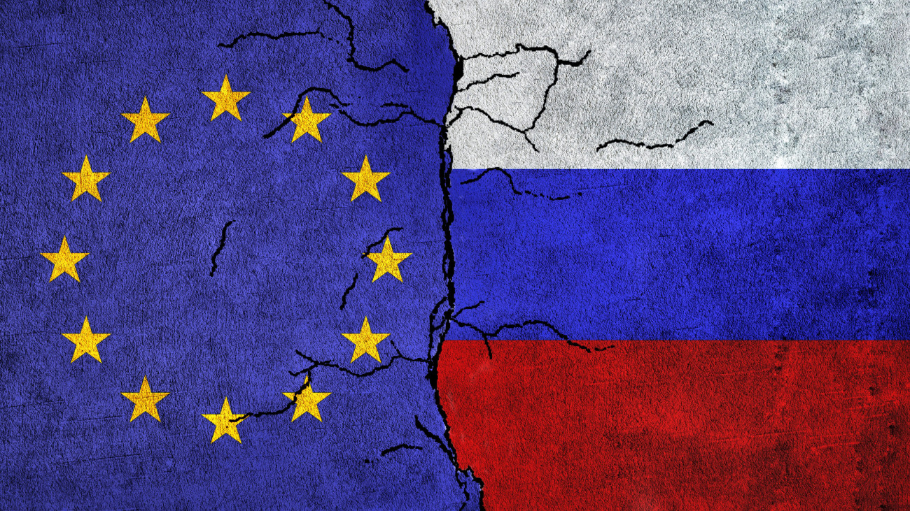Russia and European Union painted flags on a wall with grunge texture. Russia vs EU