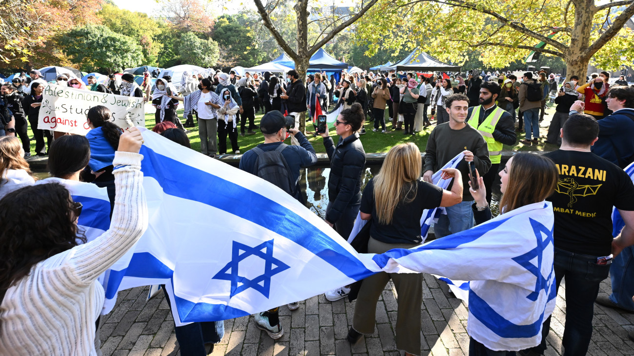 A zsidó közösség tagjai palesztinpárti tüntetőkkel átellenben tüntetnek a Melbourne-Egyetemen 2024. május 2-án. A Hamász palesztin iszlamista szervezet fegyveresei 2023. október 7-én támadást indítottak Izrael ellen, az izraeli haderő pedig válaszul légi és szárazföldi hadműveleteket hajt végre a Gázai övezetben.