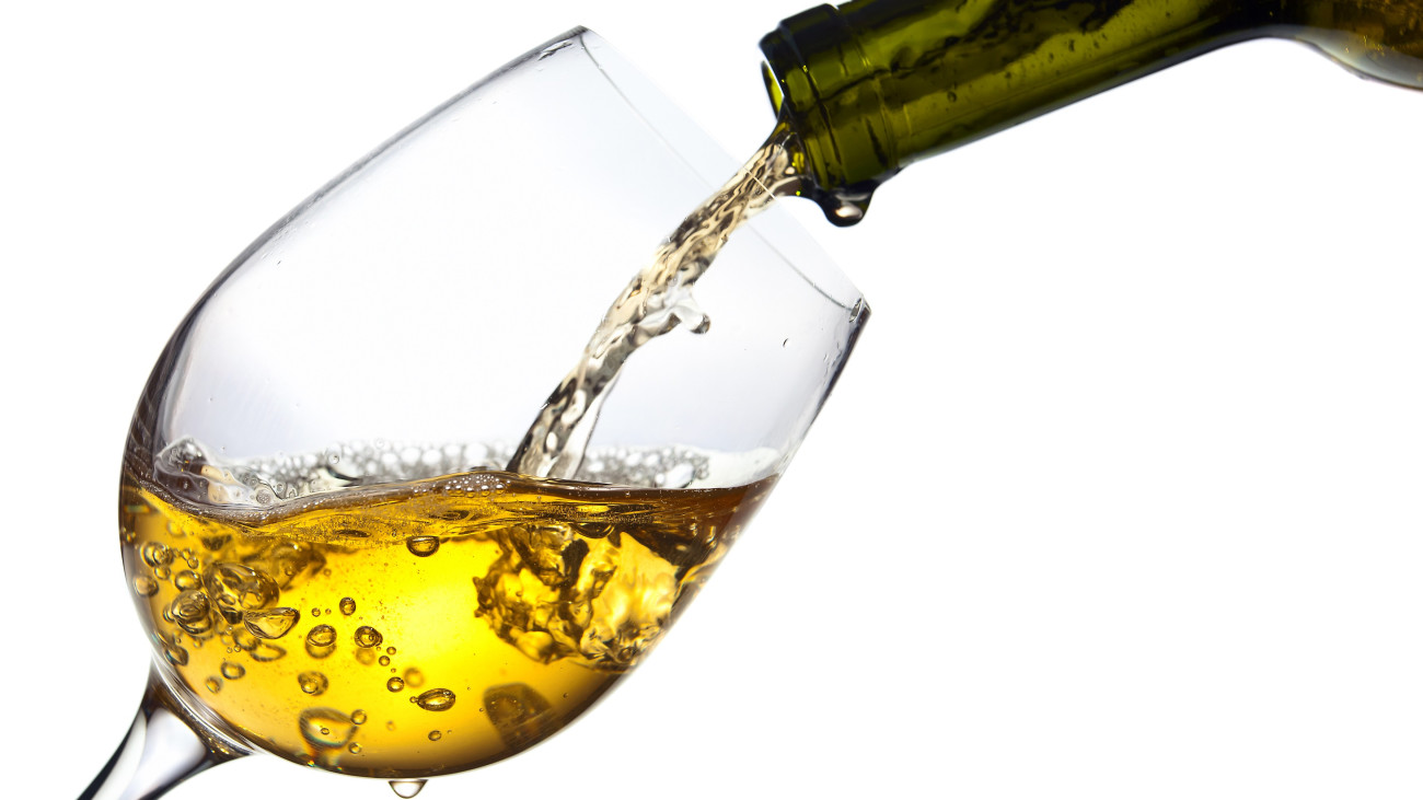 sweet wine being poured into a wineglass, isolated  on white background