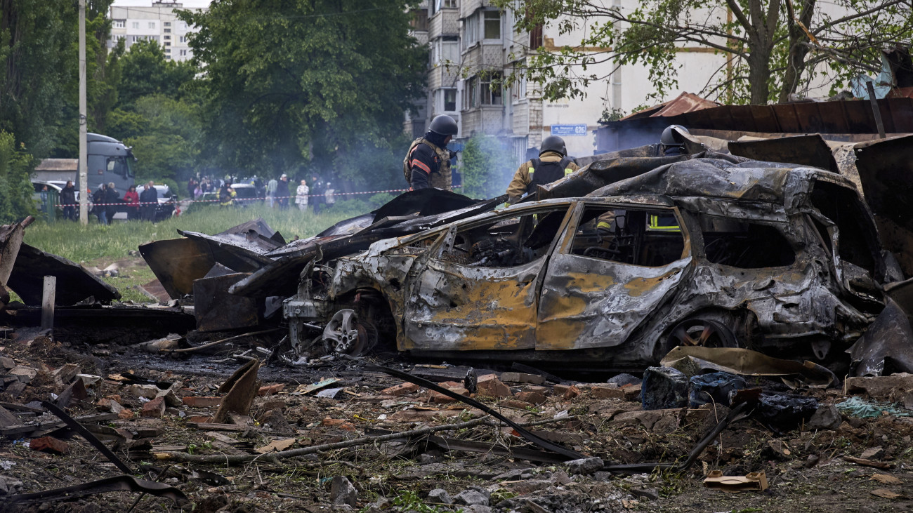 Kiégett autóroncsok mellett mentők Harkivban 2024. május 14-én, miután orosz rakéta-és siklóbomba-támadás érte a kelet-ukrajnai város egyik lakónegyedét. Ukrán források szerint legalább 20 ember, köztük 3 gyermek megsebesült.